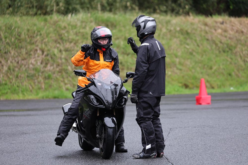 バイクにまたがった参加者へ、インストラクターが対面でアドバイスする様子